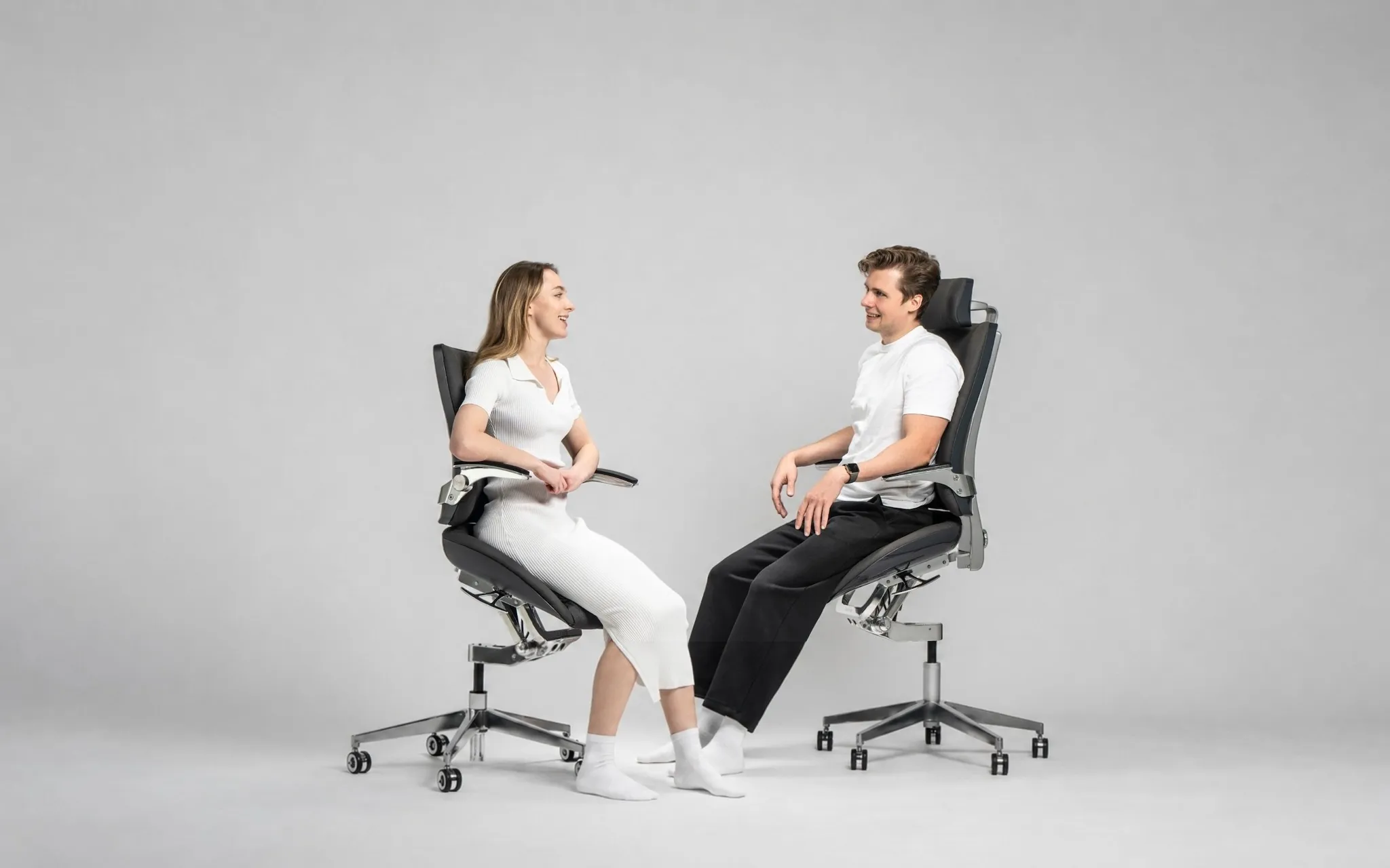 Two professionals sitting in an elevated seating position on the Levitask Vision chairs